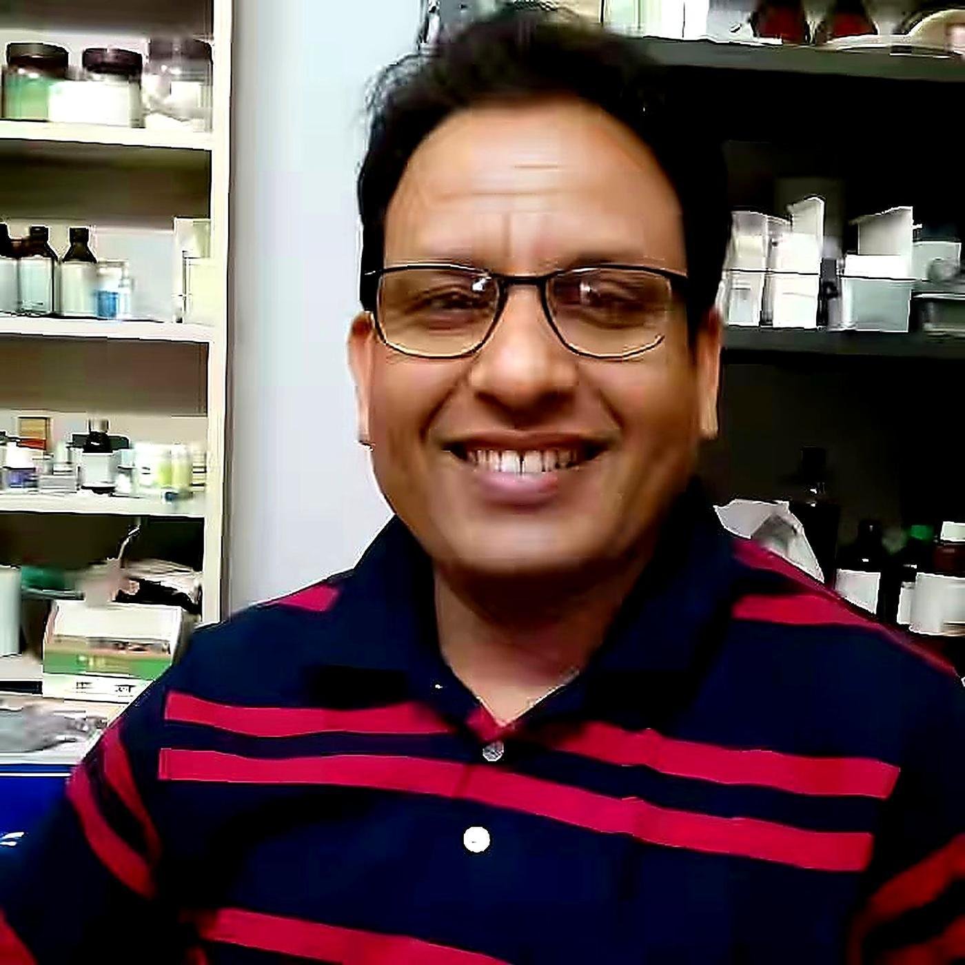 Dr. B. D. Verma at Arogya Ayurvedic Chikitsalay with medicine shelves behind
