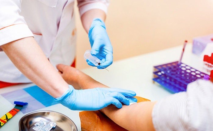 Technician collecting a blood sample with a sterile kit