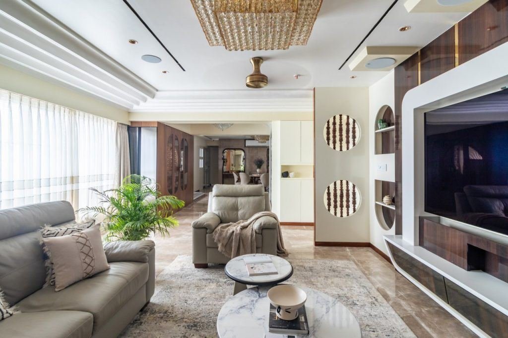Elegant Indian living room with TV wall and chandelier designed by Curated Comfort, interior designer in Gomti Nagar Lucknow