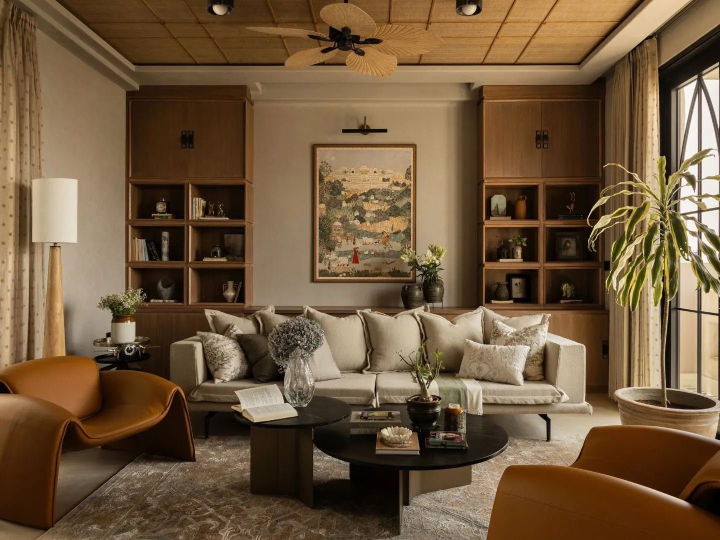 Warm contemporary living room with bookshelves and art by Curated Comfort, interior designer Lucknow
