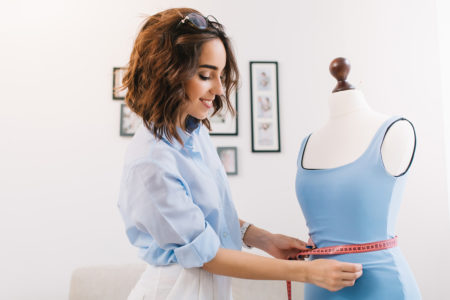 Dressmaker measuring garment on dress form