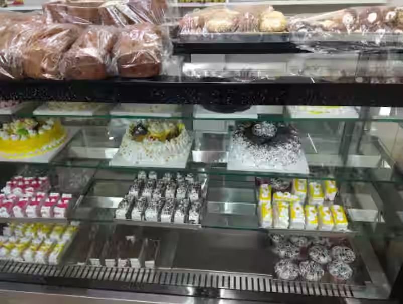 Bakery display case with cakes and pastries at Globe Bakery, Kaiserbagh Lucknow