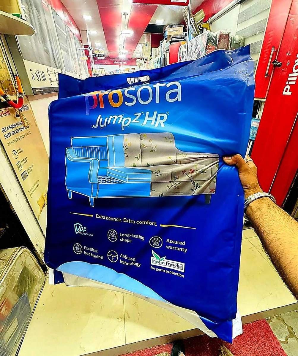 Customer holding a foam mattress pack inside Harsh Foam Agencies store, Lucknow