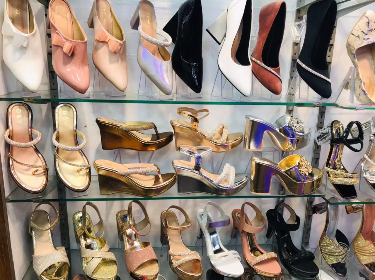 Women heels and sandals on glass shelf display