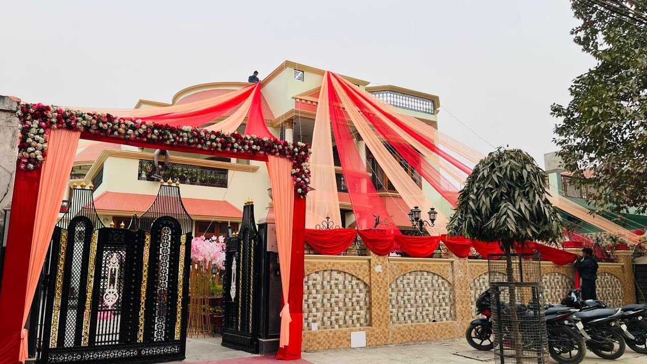 House exterior wedding decor with red drapes and floral entrance gate by Nits Events, wedding planner in Rajajipuram Lucknow
