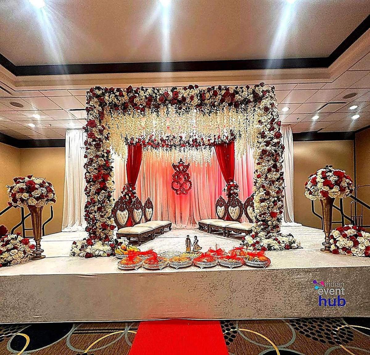 Reception stage mandap with red and white floral decor by Nits Events