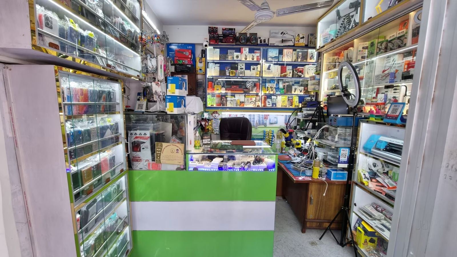 Inside Unique Mobile Repairing Centre, Indira Nagar — repair desk and accessories display